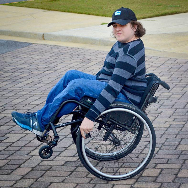 A student navigating campus in a wheelchair